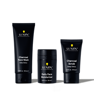 Lumin men's charcoal face wash, daily face moisturizer, and charcoal scrub skincare products in black packaging.