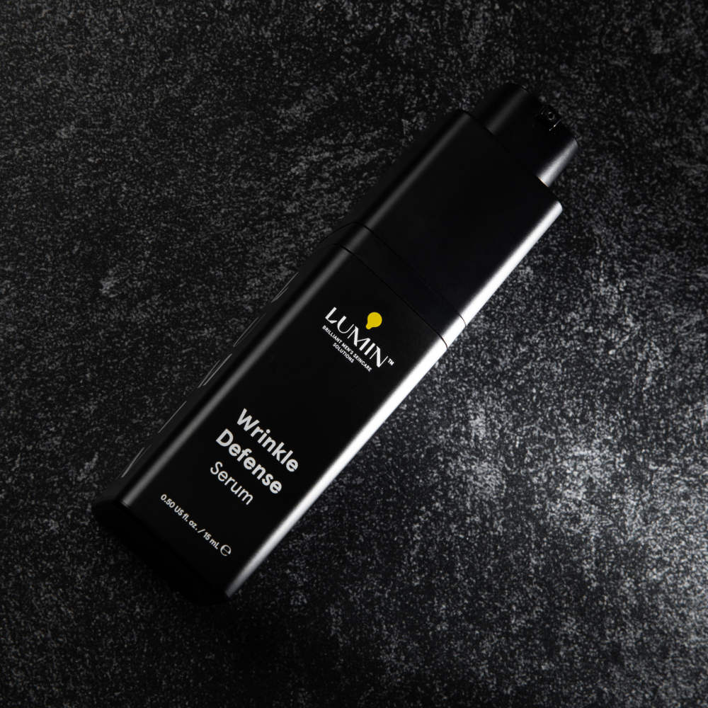 Lumin Wrinkle Defense Serum bottle on textured dark surface, men's anti-aging skincare product, 15ml packaging